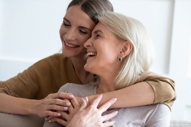 Closeup adult daughter hugs elderly mother enjoy tender moment