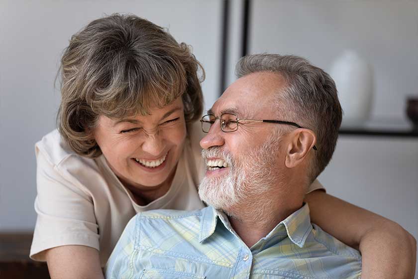 Head shot caring happy older woman cuddling joyful mature husband
