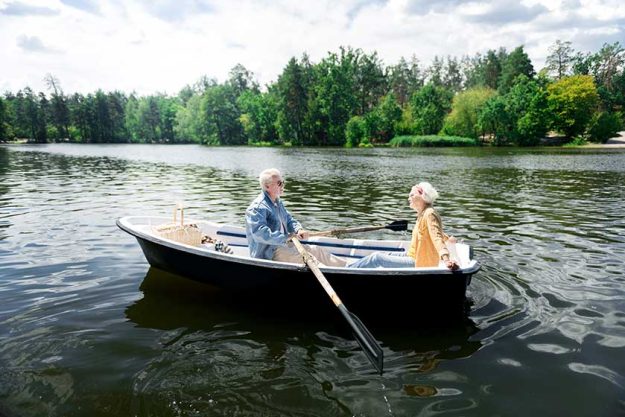 Aged beaming good-looking couple having nice boat ride while having very romantic date Aged beaming good-looking couple having nice boat ride while having very romantic date