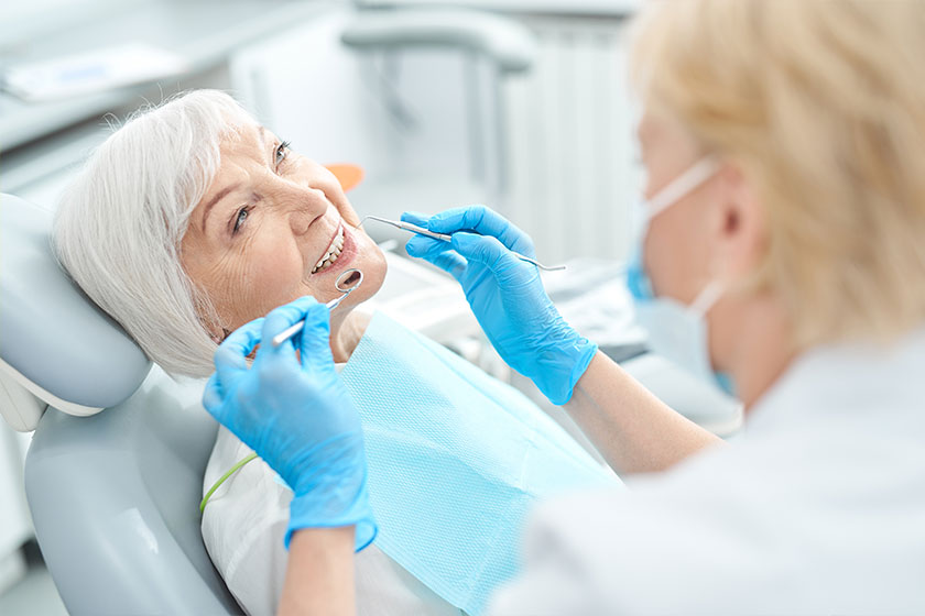 Elderly patient treating her teeth at the dentist office Elderly patient treating her teeth at the dentist office