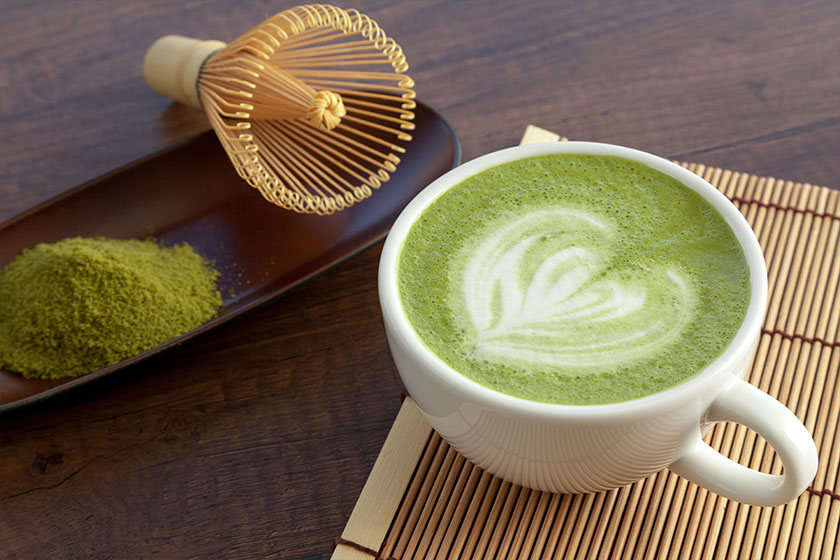 Matcha latte art heart shape on top on wooden table