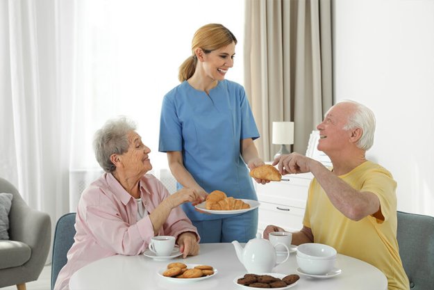 Nurse assisting while elderly people having breakfast Nurse assisting while elderly people having breakfast