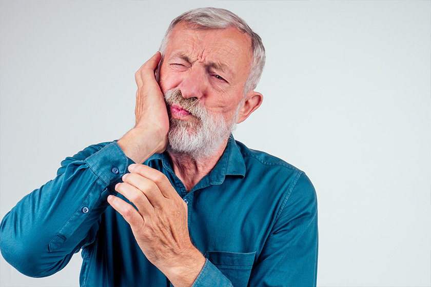 unhappy senior man with closed eyes holding cheek isolated white background