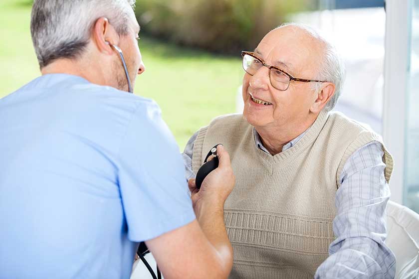 Male Doctor Measuring Blood Pressure Of Senior Man