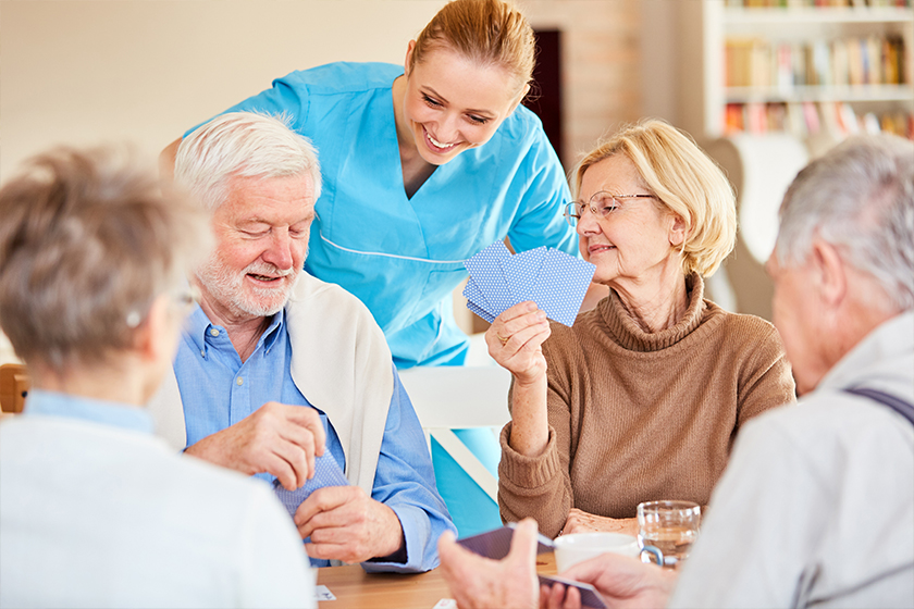 Nursing lady looks on while playing cards