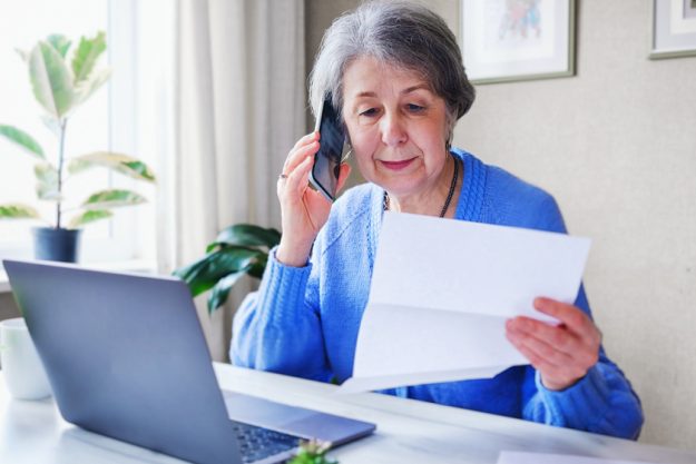 An elderly woman pays taxes or other bills online – A pensioner An elderly woman pays taxes or other bills online - A pensioner