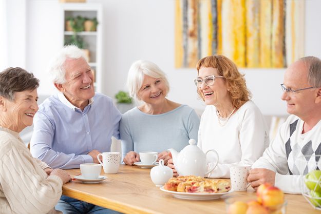 Group of happy older people laughing together on a coffee meeting