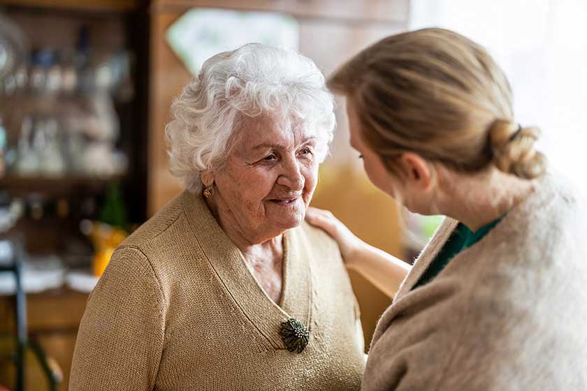 Health visitor talking to a senior woman during home visit