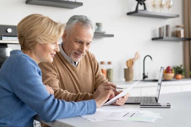 Mature family couple check utility bills together