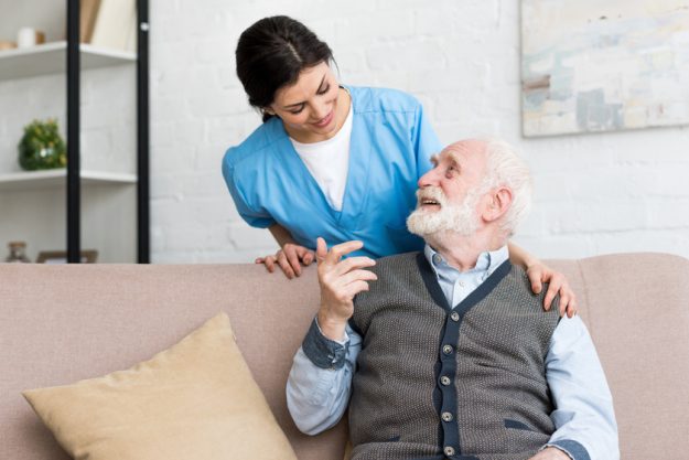 Doctor standing behind senior man, talking to happy patient A Guide To Evaluating Assisted Living For Seniors In Irving, TX