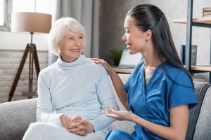 Nurse assisting with elderly woman at home