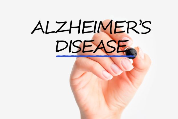Woman hand writing Alzheimer’s disease on screen Understanding The Symptoms Of Alzheimer's Disease In Your Loved One