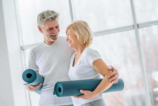 Health and sport concept. Senior couple with yoga mats in the gy X Ways Retirement Communities In Oklahoma Promote Health
