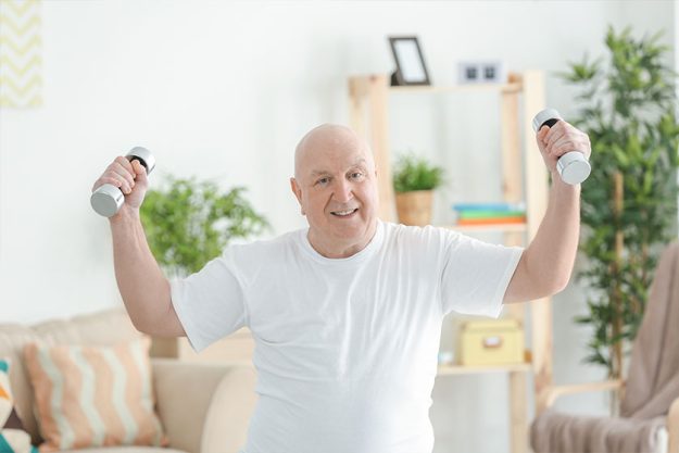 Fat senior man training with dumbbells at home Fat senior man training with dumbbells at home