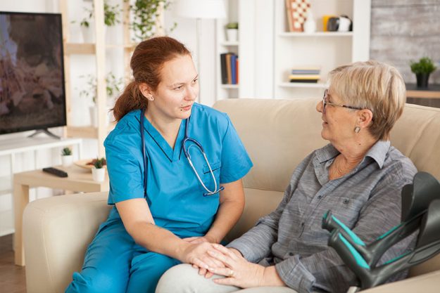 Female nurse having a conversation with pensioner woman Female nurse having a conversation with pensioner woman