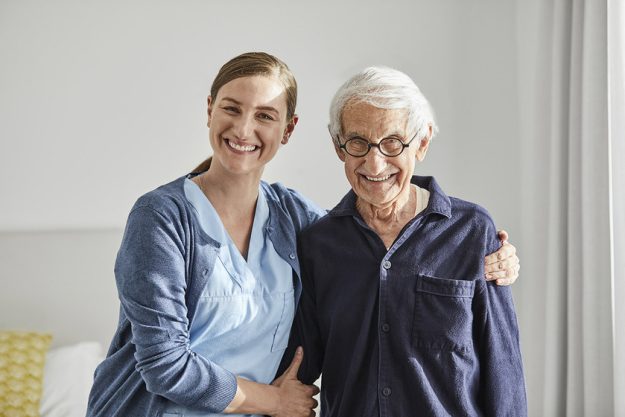 Happy senior male with female caregiver Happy senior male with female caregiver