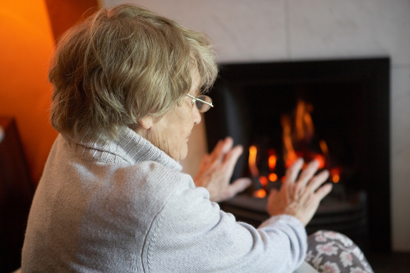 Senior Woman Warming Hands By Fire At Home Some Things Seniors Can Do to Stay Safe In Cold Weather In Arlington, TX