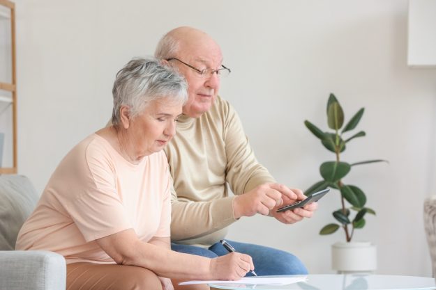 Senior couple calculating expenses at home Senior couple calculating expenses at home
