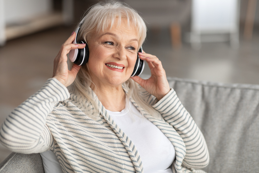 Satisfied smiling mature woman listening to music Satisfied smiling mature woman listening to music