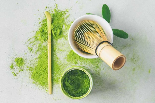 Flat lay of organic Japanese green tea and tools Chasen bamboo whisk
