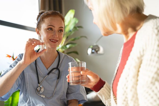Positive delighted young doctor showing useful vitamin Positive delighted young doctor showing useful vitamin