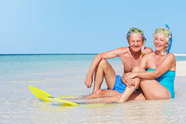 Senior Couple With Snorkels Enjoying Beach Holiday Retiring In Active Adult 55+ Communities In Hughes, TX: 7 Must-Visit Area Attractions