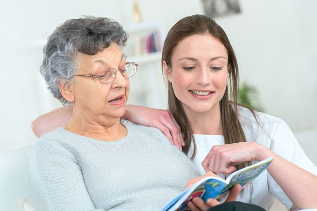 woman and senior woman with book