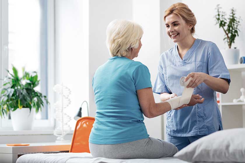 Cheerful professional nurse cheering up her patient