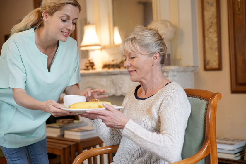 Nurse bringing breakfast to senior female patient How To Transition Your Loved One From A Nursing Home To Assisted Living In Euless, TX
