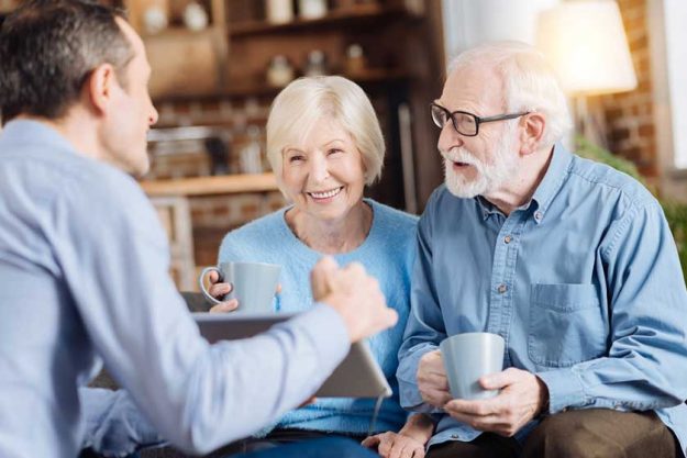 Loving son showing something on tablet to his parents