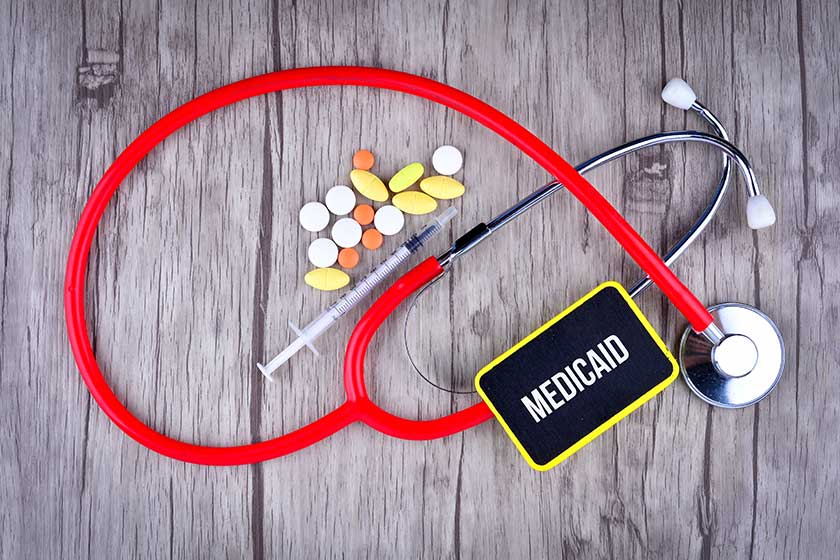 Pills, Syringe and Stethoscope with text Medicaid