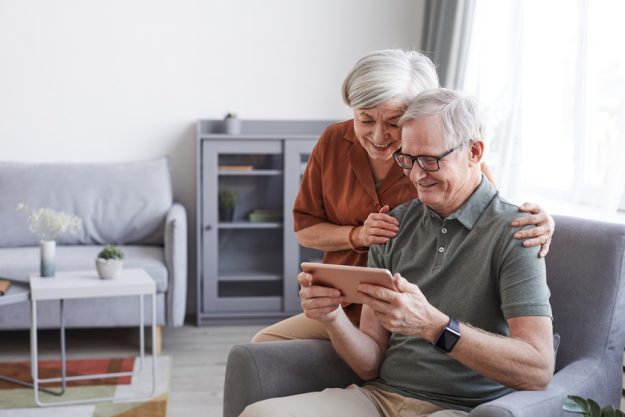 Happy Senior Couple Using Tablet Retiring In Active Senior Living Homes In Victoria County: The Gulf Of Mexico Offers You A Healthy Environment To Live