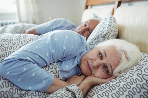 Senior woman awake on bed