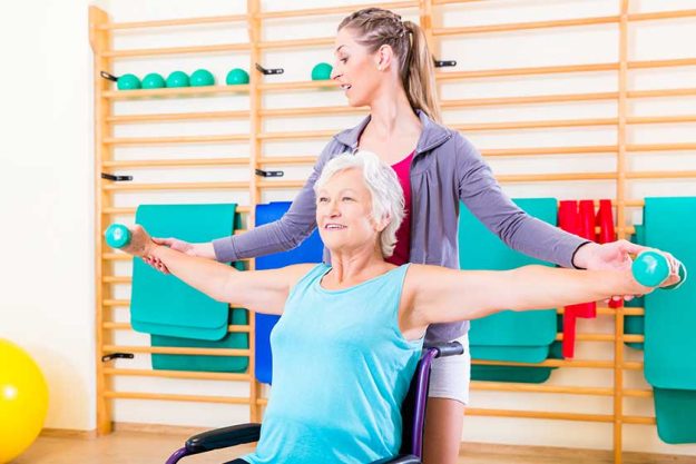 Senior woman in wheel chair doing physical therapy