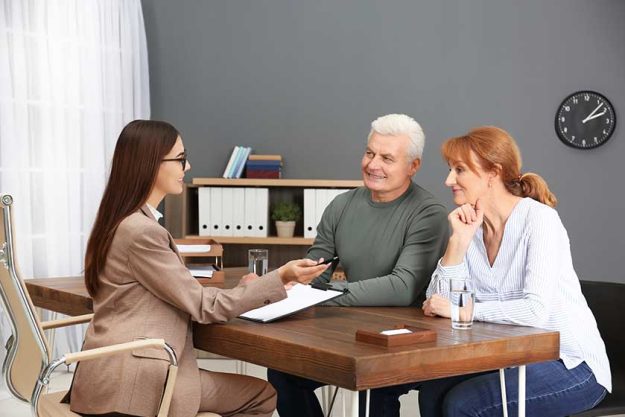 Young lawyer consulting senior couple in office Young lawyer consulting senior couple in office