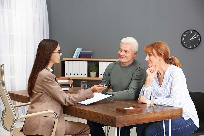 Young lawyer consulting senior couple in office