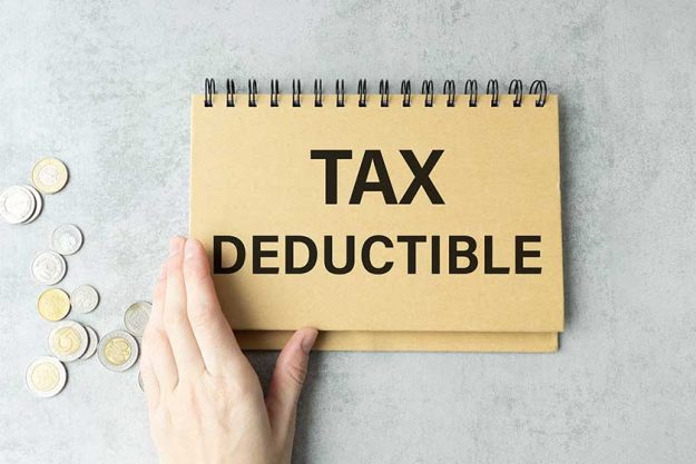businessman holding a card with text TAX DEDUCTIBLE