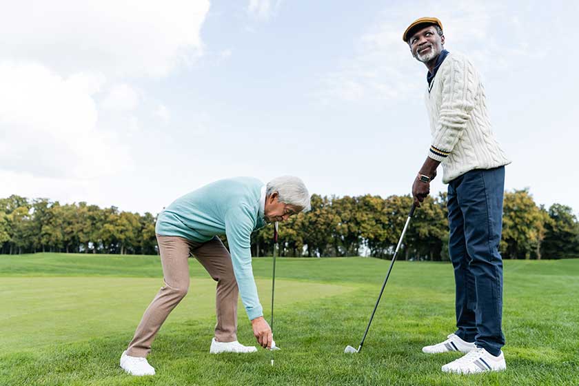 Asian senior man putting ball on golf tee