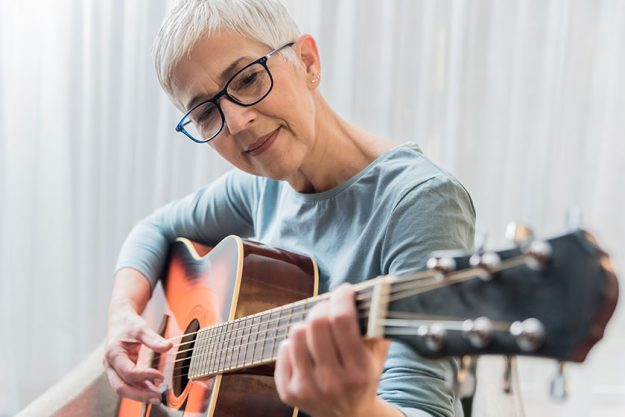 Cheerful Charming Beautiful Mature Woman Enjoy Playing Guitar