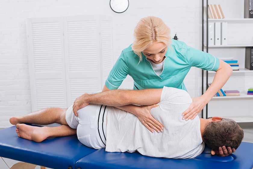 Chiropractor massaging back on patient
