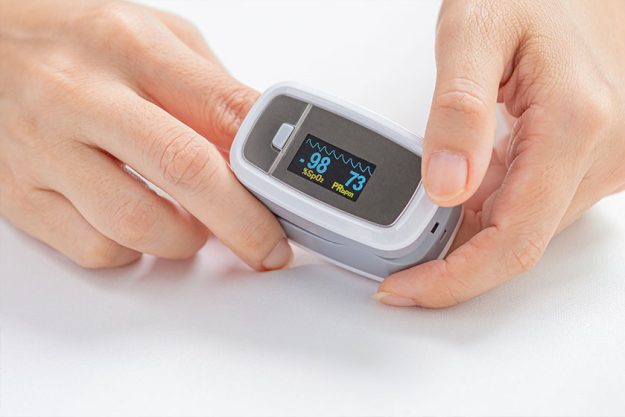 Close Woman Using Digital Pulse Oximeter Close Woman Using Digital Pulse Oximeter