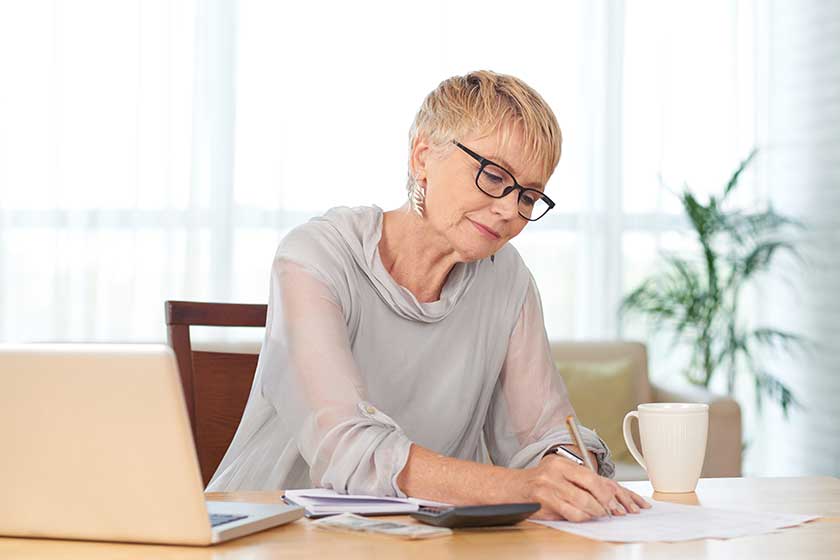 Elegant senior woman writing down household