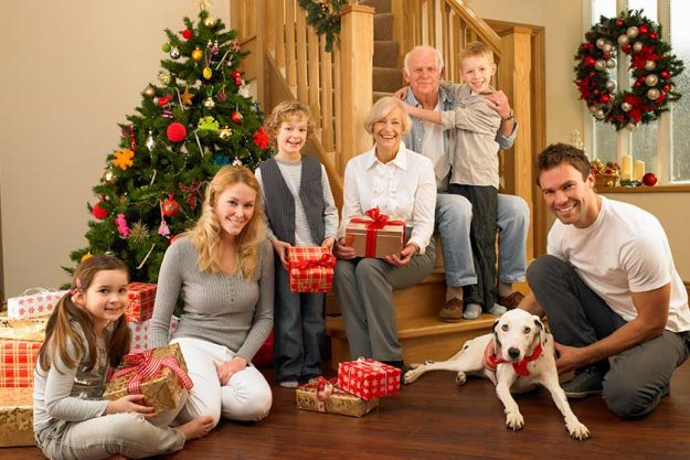 Family with gifts in front of Christmas tree
