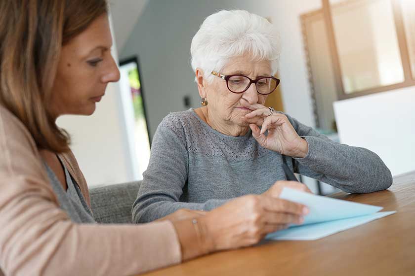 Home assistant helping elderly woman with paper work