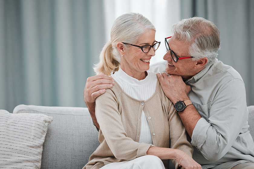 Love, hug and mockup with a senior couple sitting on a sofa
