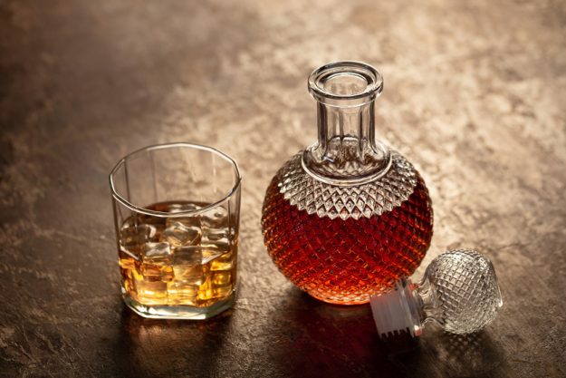 Bottle whiskey and Glass of whiskey with ice on black background How Much Alcohol Can Your Aging Body Tolerate?