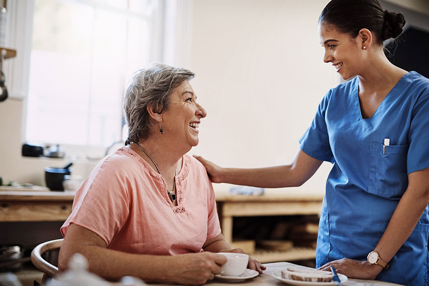 an attractive young female caregiver with a senior patient in a nursing home