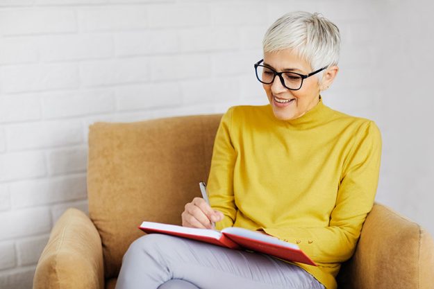 Portrait of a beautiful senior woman writing in a notebook Portrait of a beautiful senior woman writing in a notebook