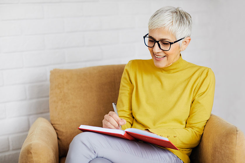 Portrait of a beautiful senior woman writing in a notebook
