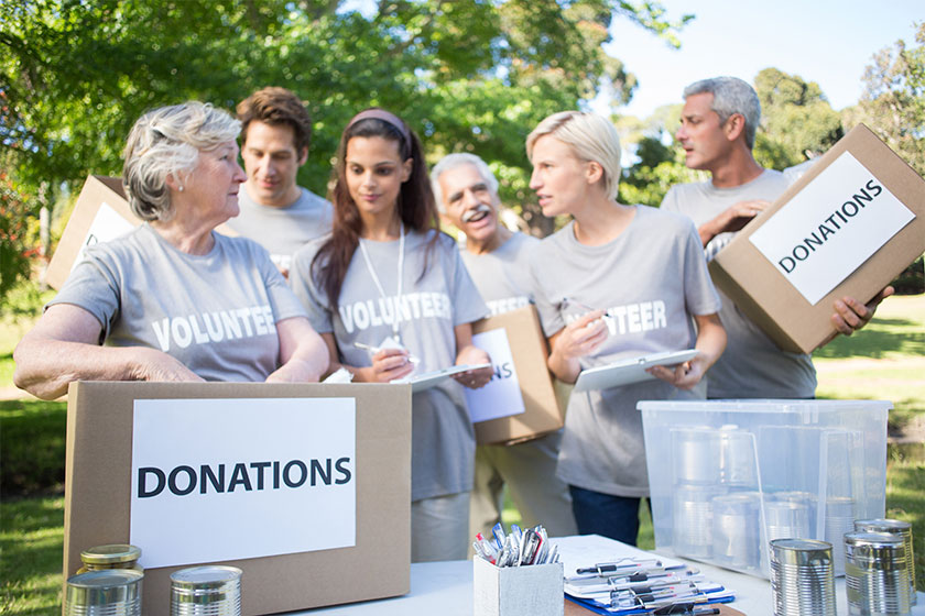 Happy volunteer family holding donation boxes Happy volunteer family holding donation boxes